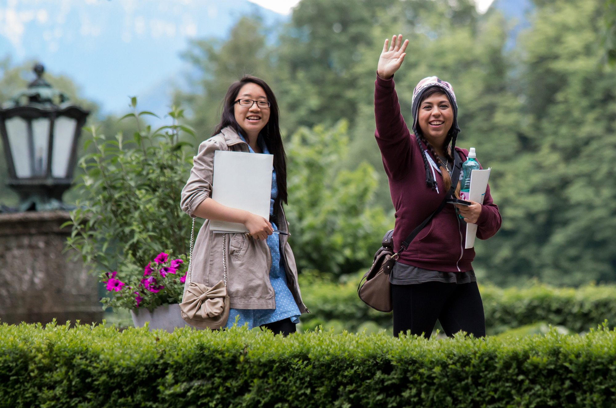 2 people smiling and waving